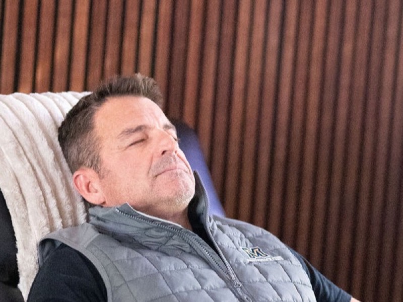 Client relaxing in zero gravity chair during treatment